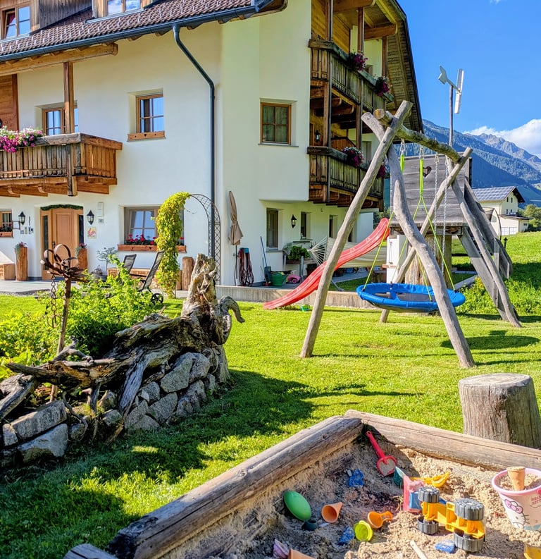 a sandbox with a sandbox and a wooden swing set