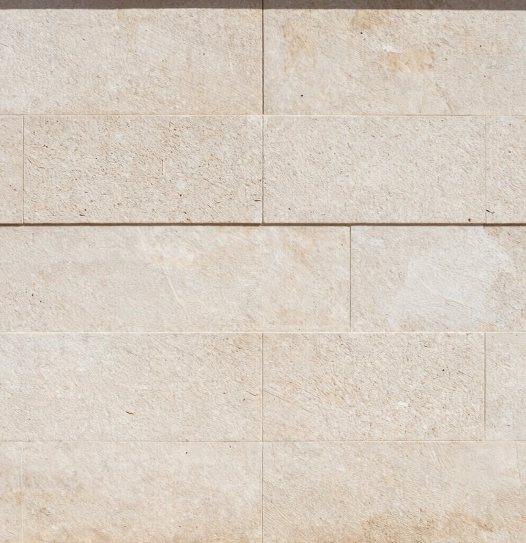 Texture photography of a light stone wall with subtle shadows, Spanish-speaking architectural style, clean and timeless aesthetic.
