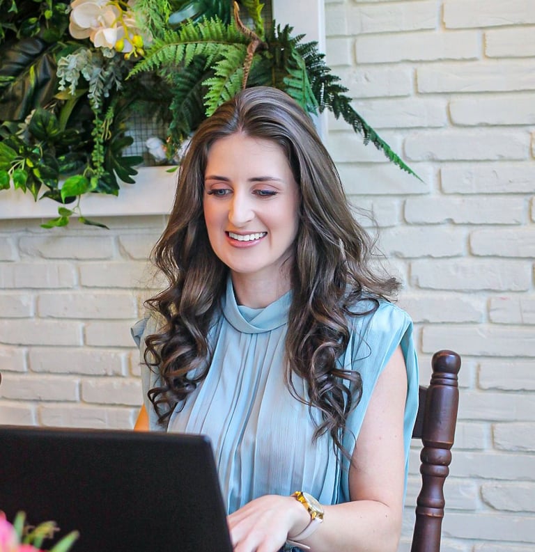 Foto da nutricionista em Jaraguá do Sul, Kamila Kuester, sorrindo enquanto olha para o notebook
