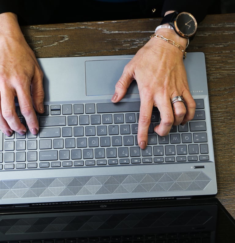 Hands typing on a laptop