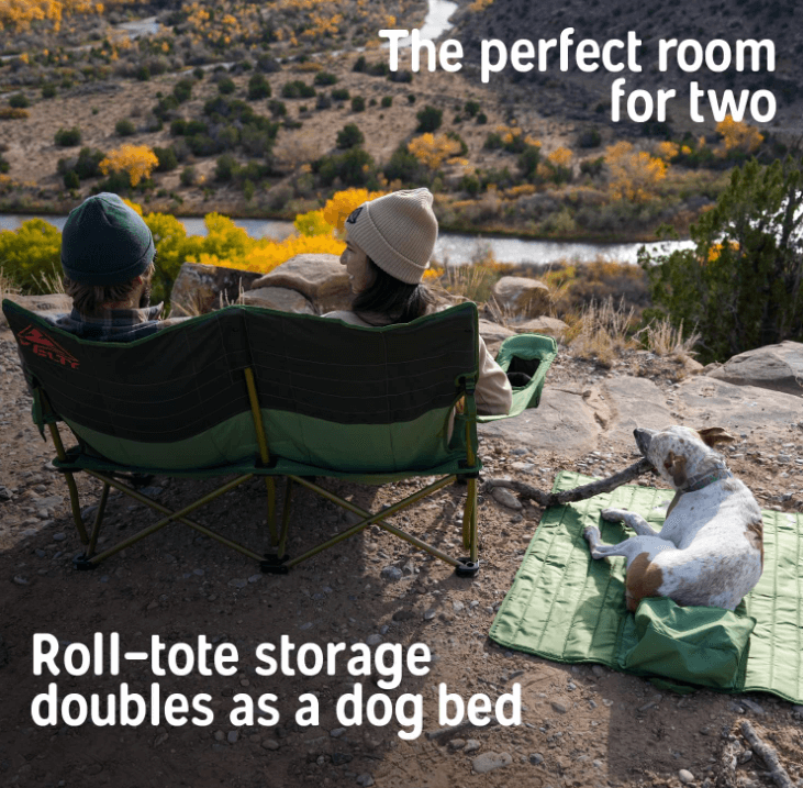 Camping couple sitting in a Kelty loveseat camping chair, with dog using roll-tote bag as bed