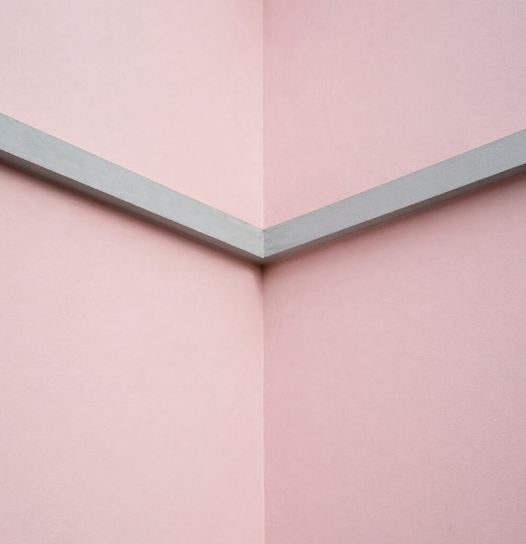 A minimalist architectural detail showing the intersection of light pink walls and clean grey lines under soft natural light.