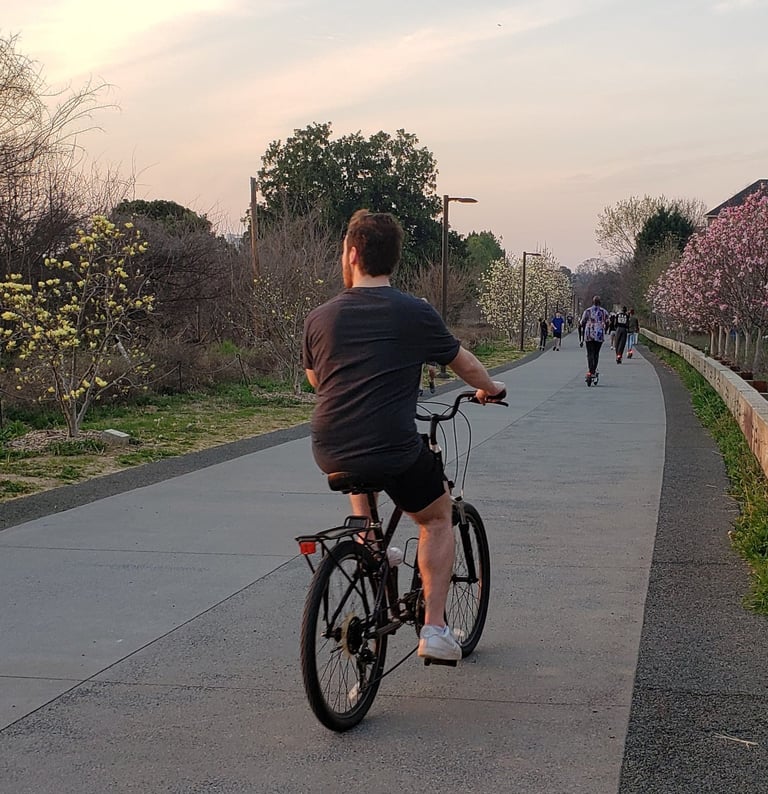 People riding bikes on a path at sunset