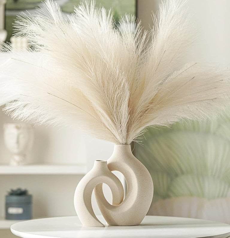 Cream faux pampas grass in a modern intertwined ceramic donut vase for aesthetic home decor.