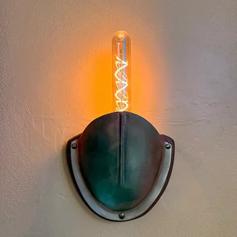 Sconce made from brass boat vent with LED light.