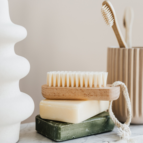 2 bars of soap stacked on top of each other & a nail brush on top of them