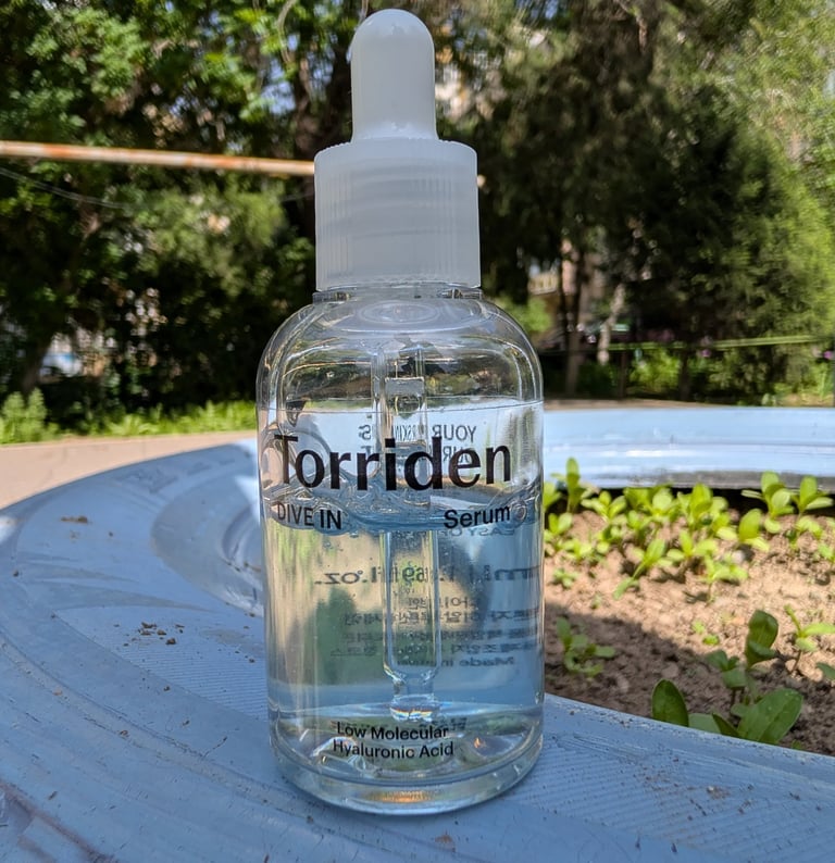 Torriden Dive In Low Molecular Hyaluronic Acid Serum in a clear bottle outdoors.