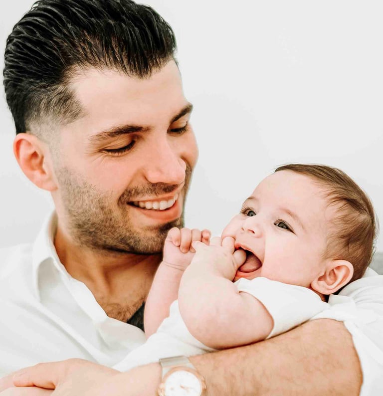 Father smiling while holding baby – Fred Art Studio family session