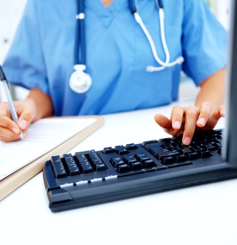 Nurse typing documentation on the keyboard..