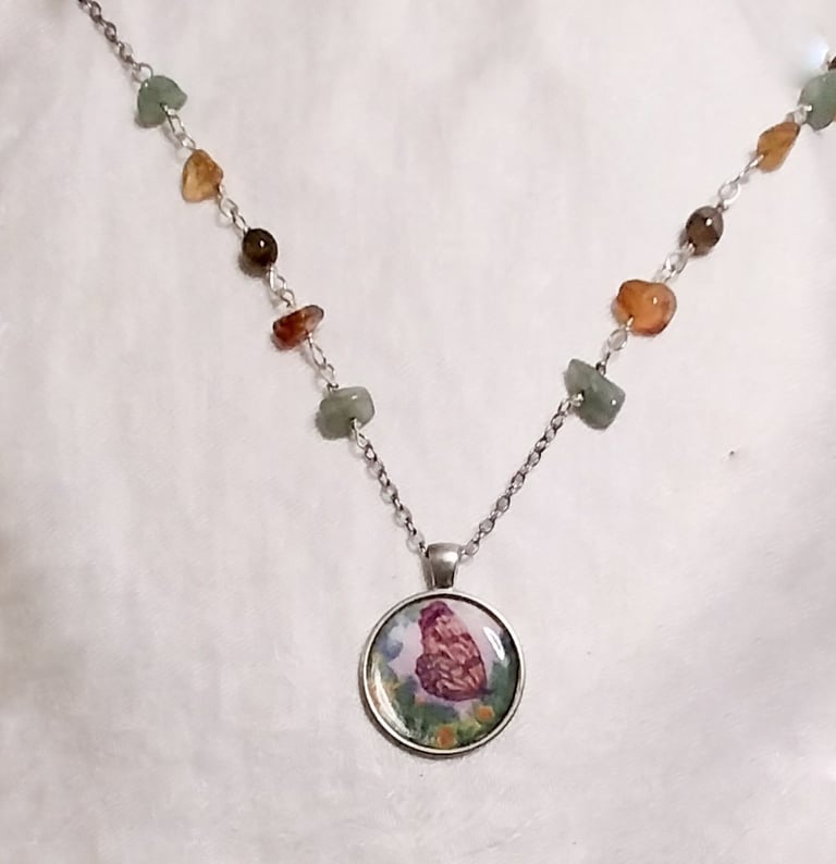 a necklace with a butterfly and flower on it