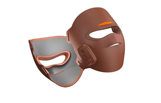 A sleek, high-tech brown LED facial mask showing its ability to reach 360 degrees.