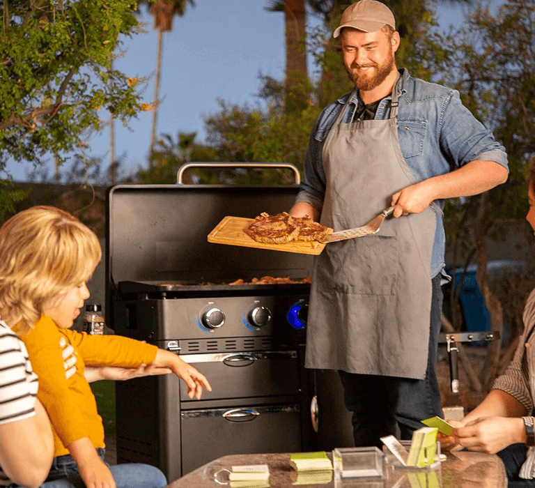 a man and woman cooking on a Pit Boss griddle