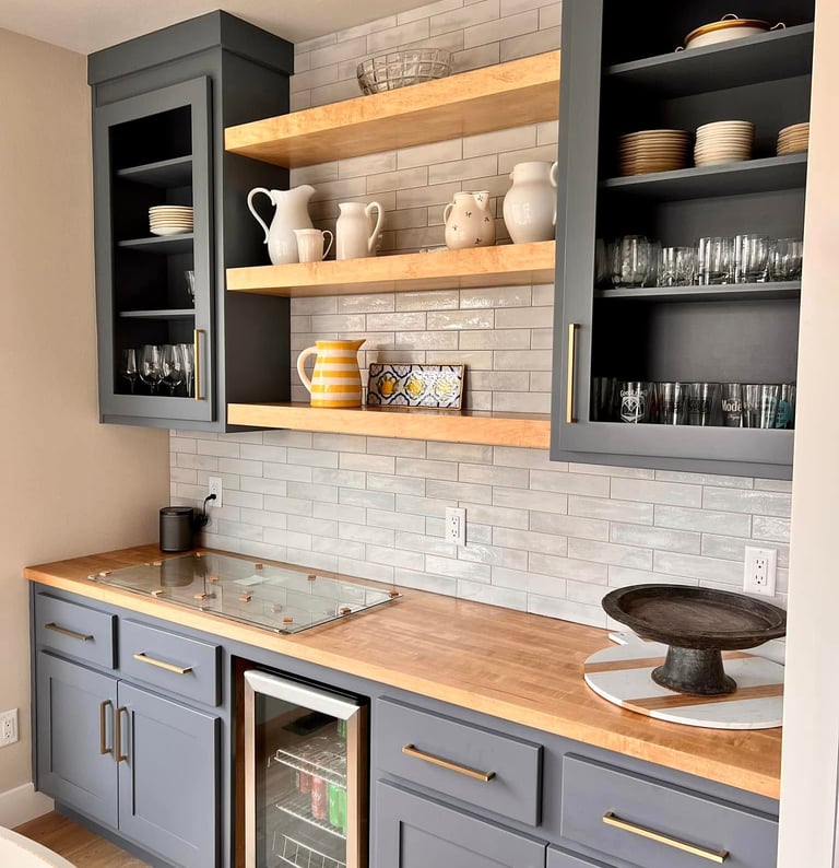 Modern home bar featuring gray cabinets, wooden countertops, and open shelving with subway tile backsplash.