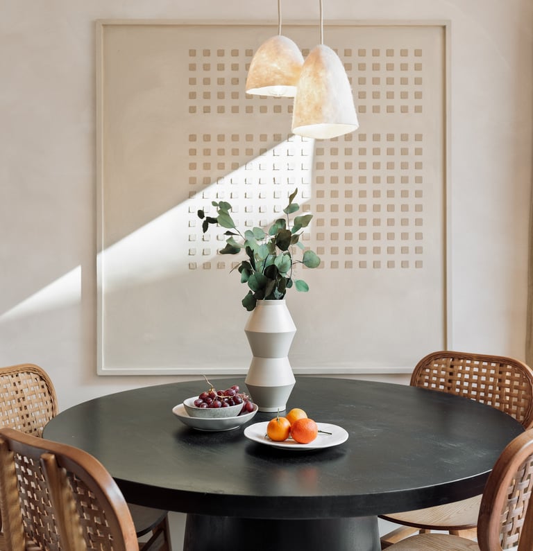Subtle dining area with custom art piece and natural wood accents in Barcelona