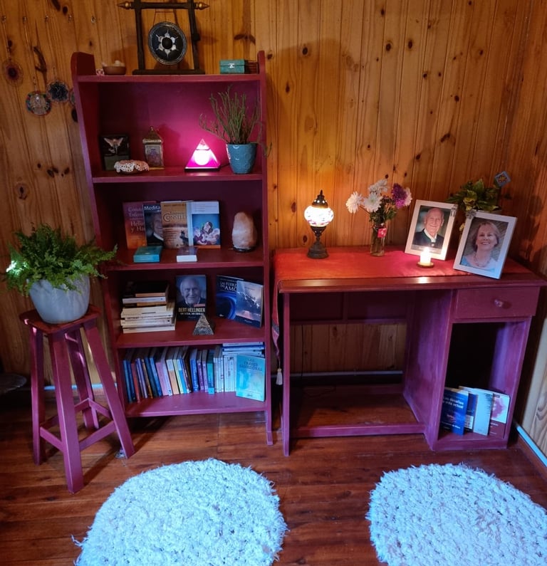 Escritorio con fotos y lampara dentro de una cabaña de madera, lugar de trabajo de Mariel Hilgert