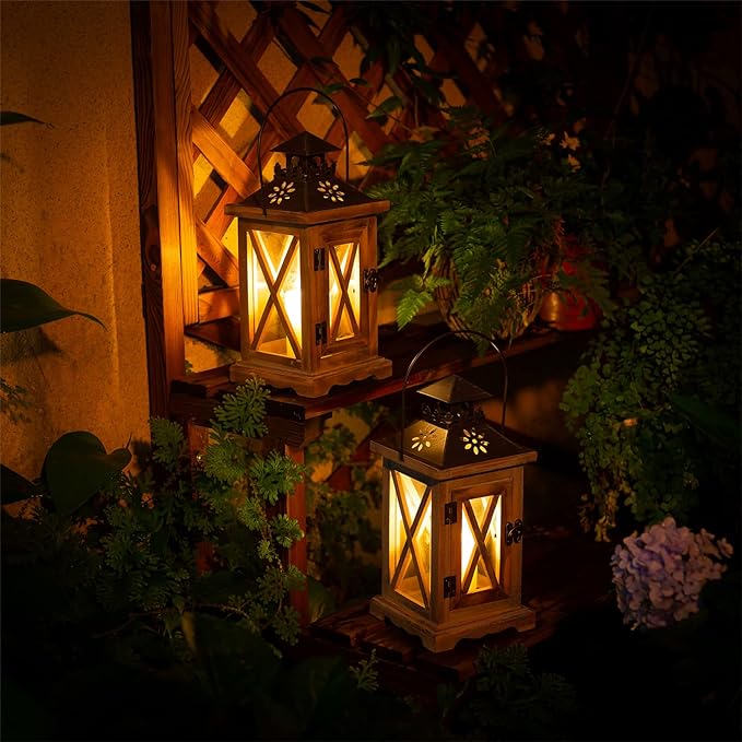 two lanterns with lights on a wooden table