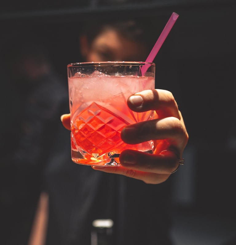 a person holding a drink in a glass