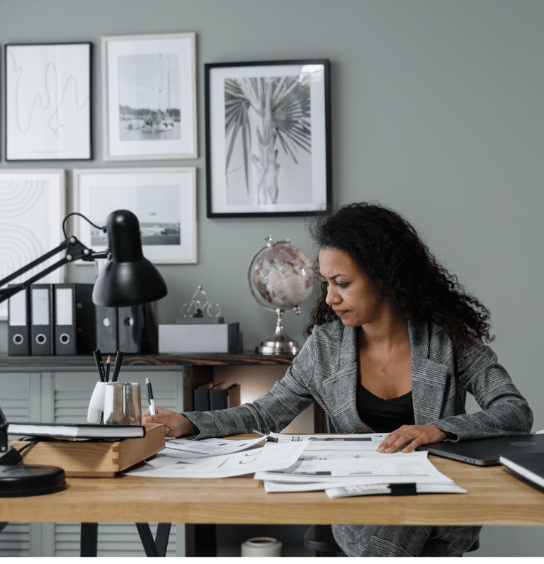 a woman sitting at a desk with a laptop and papers
