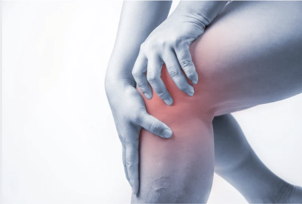 Person holding their knee in pain with a red highlight indicating inflammation or joint injury.