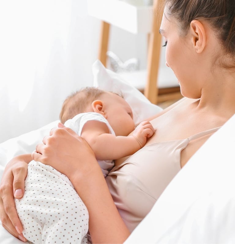 IBCLC žindymo konsultantė Eglė Gurčinė rodo kūdikio žindymo padėtį mamai per konsultaciją namuose.