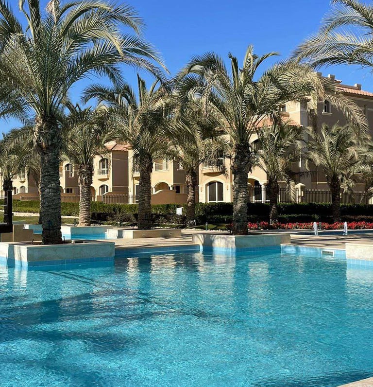 La Vista residential compound swimming pool with palm trees and luxury villas
