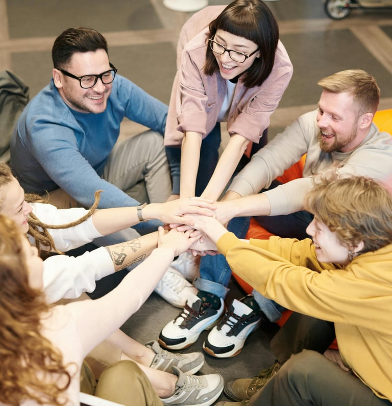 a group of people sitting around a group of people holding hands
