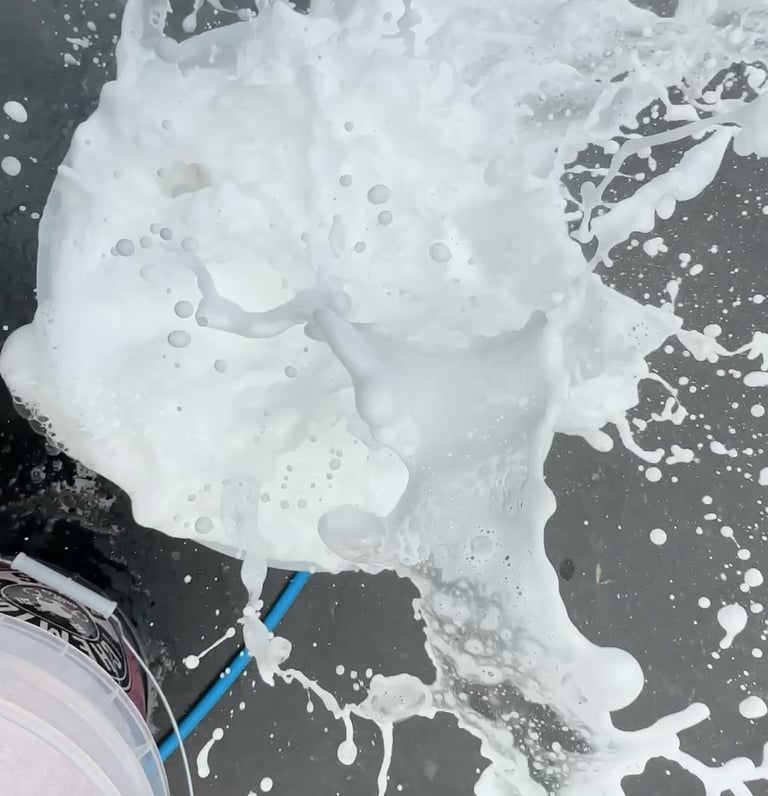 mobile detailing bucket showing foam splashing as a sponge falls in to water