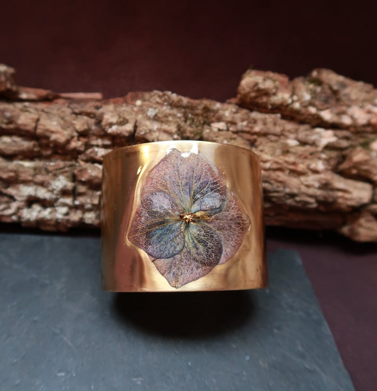 les bracelets styx manchettes dorés aspect magique, irréel, ornés de fleurs et de plumes