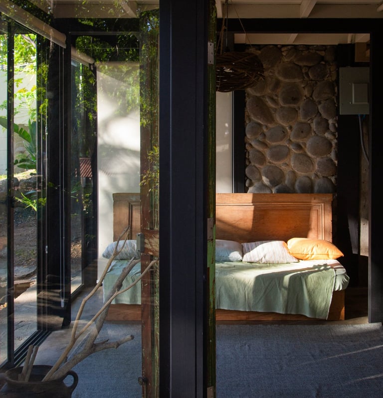 living room with a couch and lots of windows on a beautiful stone wall