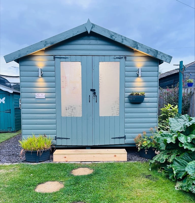 a small shed with a wooden shed and a garden