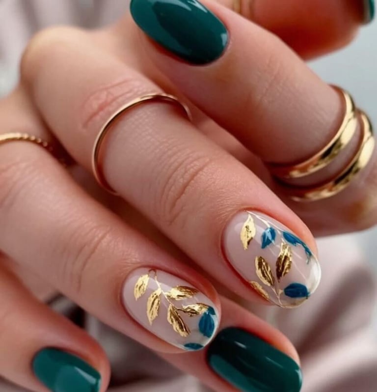 Emerald green fall nails with gold foil leaf accents on short rounded nails.