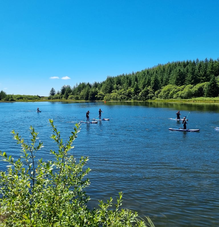 Paddle board lesson on Llyn Pendam with sunny skies