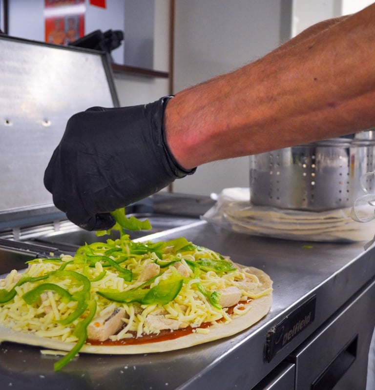 a person wearing gloves and gloves is preparing to make a pizza