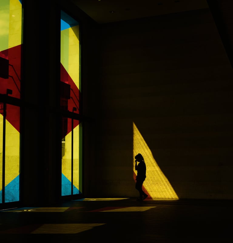 silhouette d'une femme dans le hall d'une gare aux fenêtres colorées
