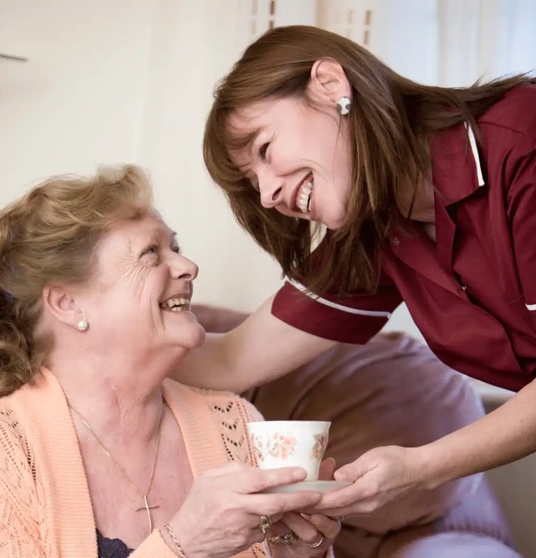 AMG Nurse giving patient a cup of tea