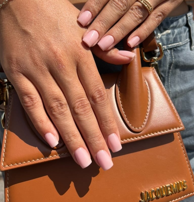a woman's hands with a brown leather handbag