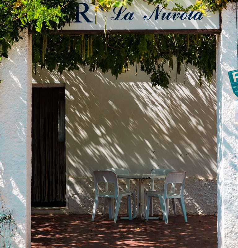 Vintage bar entrance with table and chairs in Alghero, Sardinia