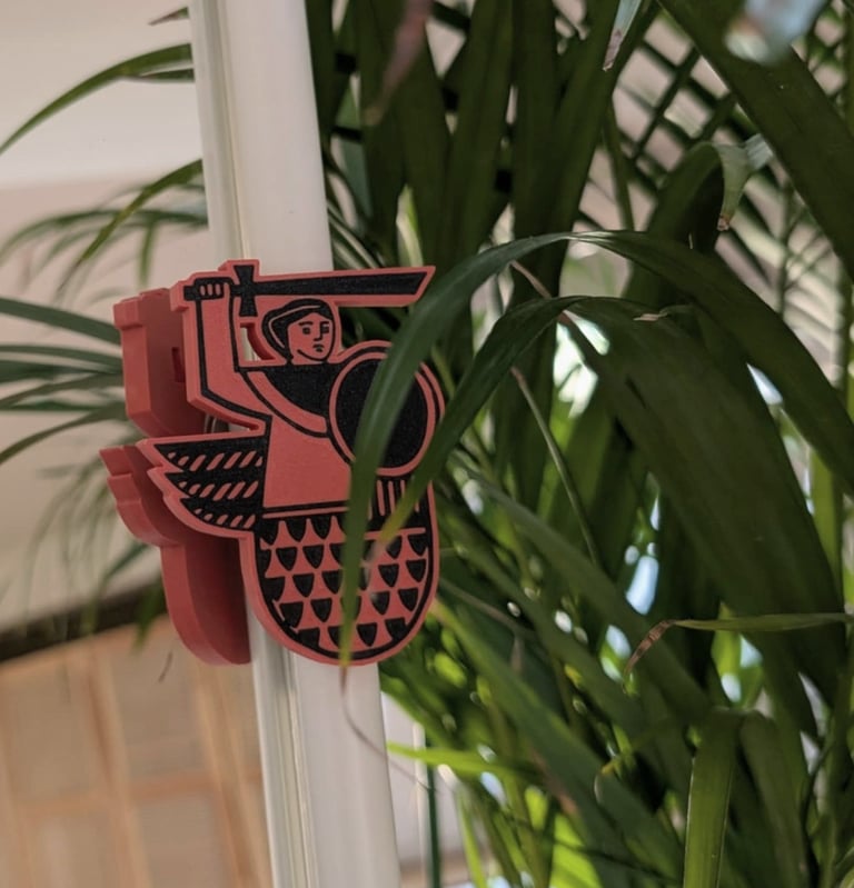 Zbliżenie na magnes z Syrenką Warszawską, druk 3D, kolorystyka ceglanych kamienic