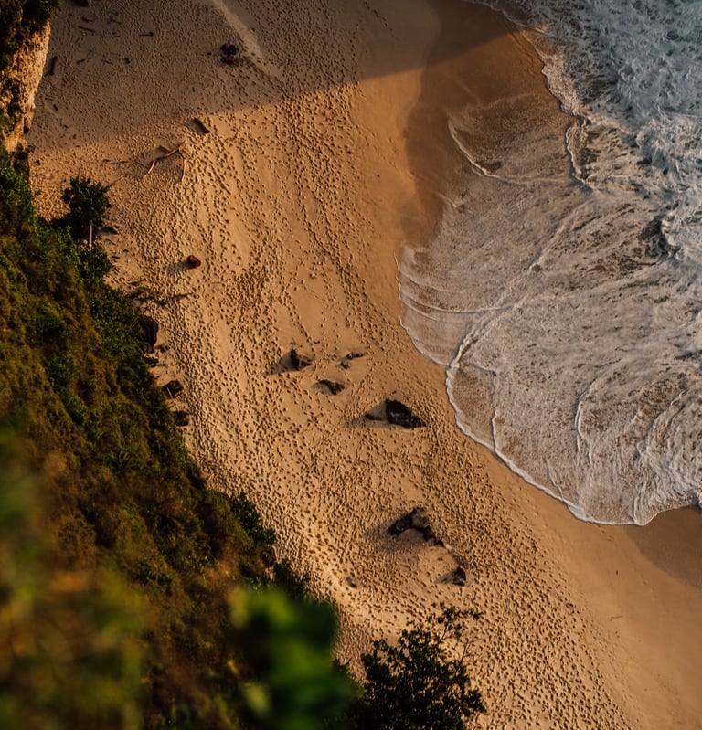 a person walking along a beach with a surfboard
