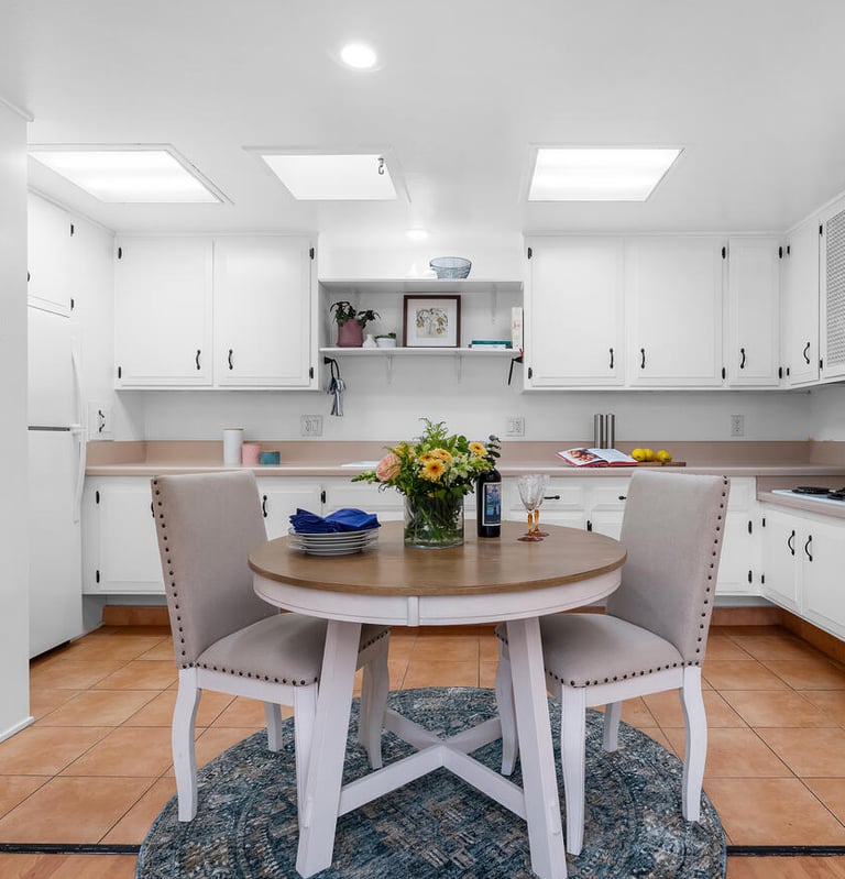 after staging: a kitchen with a table and chairs in the middle of the room
