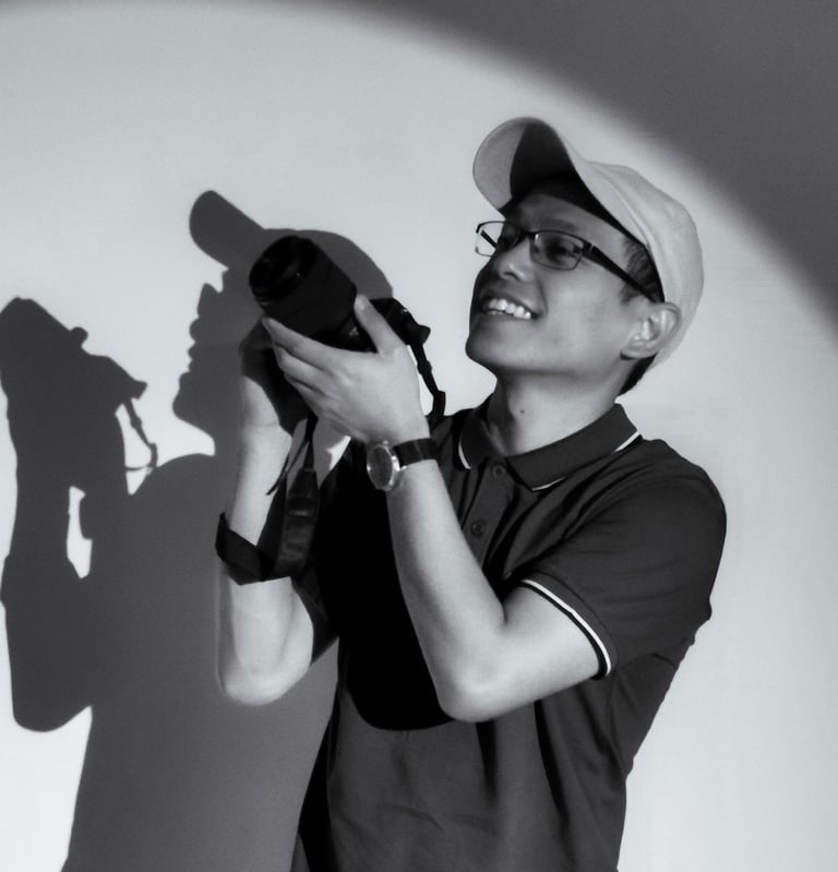 Smiling photographer holding a DSLR camera with a circular spotlight effect and shadow.