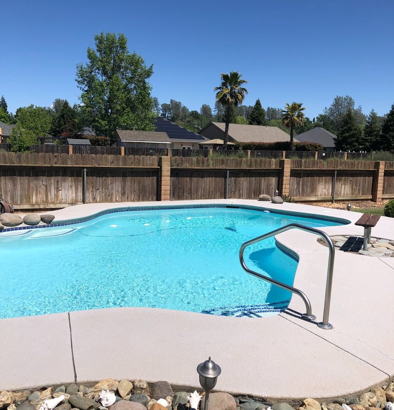 a fenced backyard with a pool 