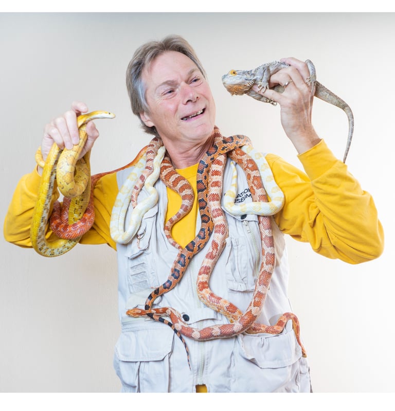 Rick Teepen holding snakes and a bearded dragon