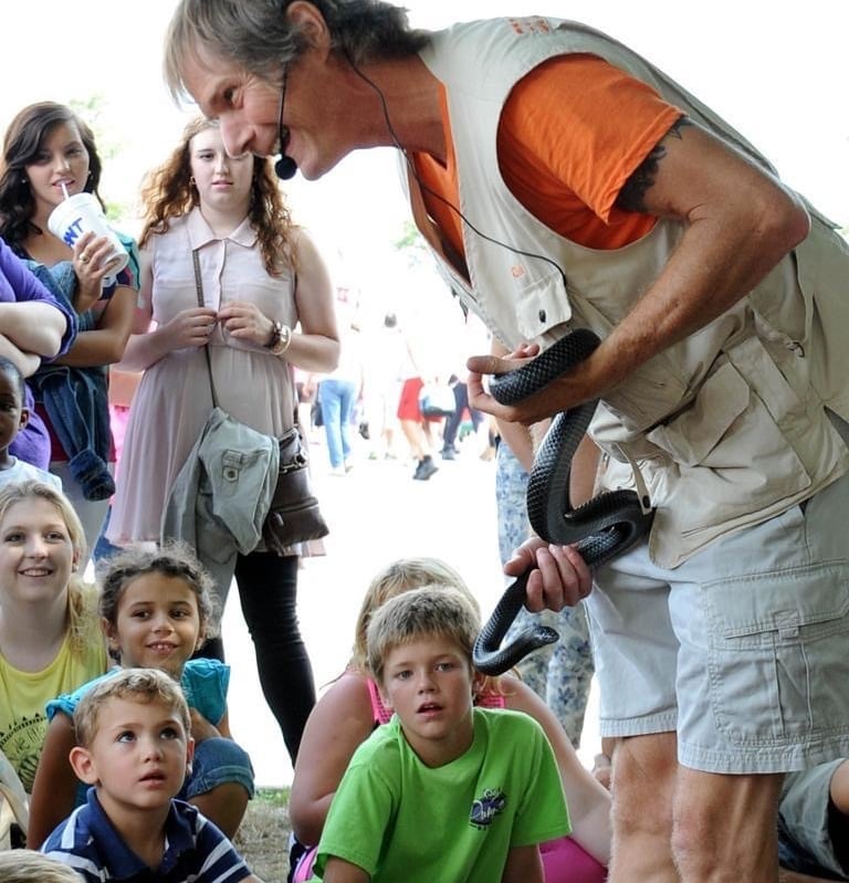 rick teepen holding a snake with children in the audience