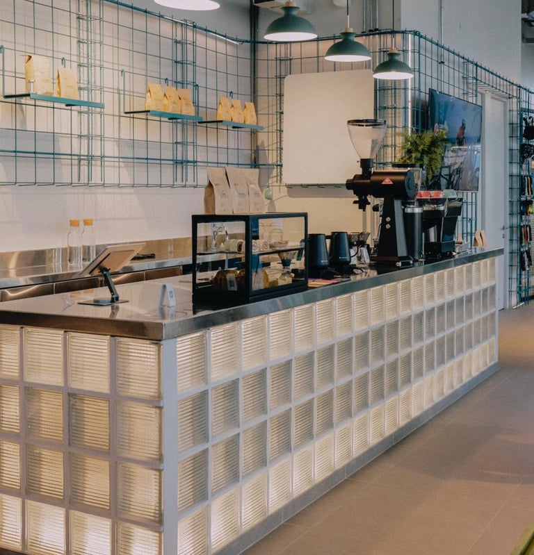 Una cafeteria con barra y mostrador, iluminacion integrada