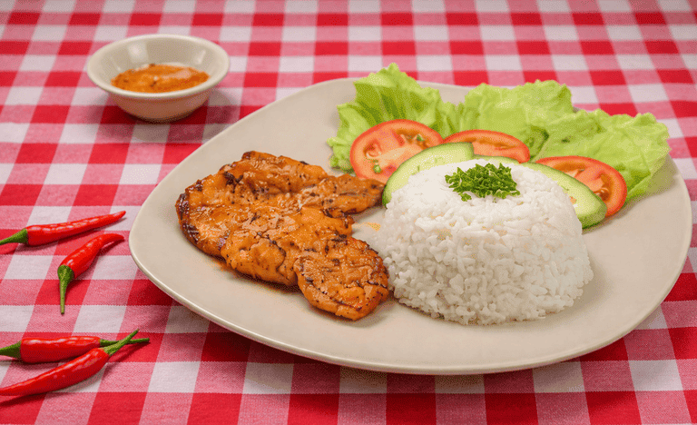 Plato de milanesa con arroz y ensalada sobre una m esa de cuadros rojos con blanco