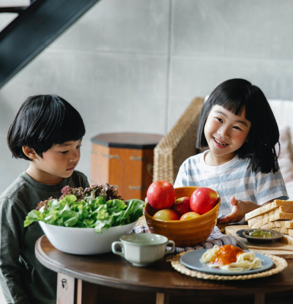 uma família sentada à mesa com comida