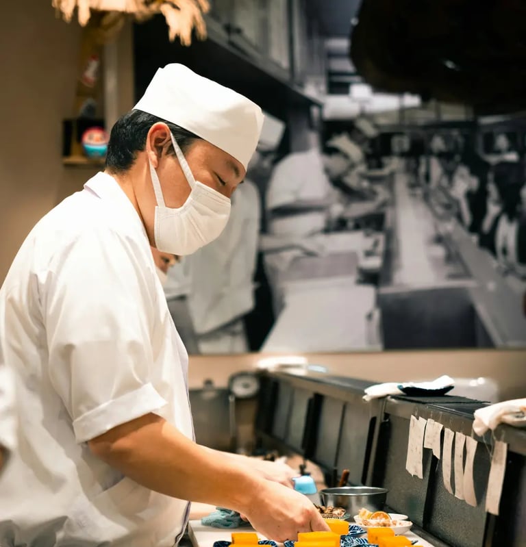 Japanese sushi chef (itamae) in a white uniform and chef's hat