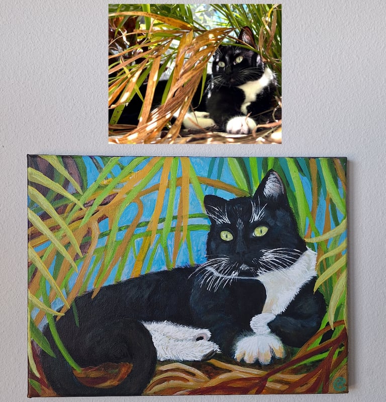 cat sitting under palm tree