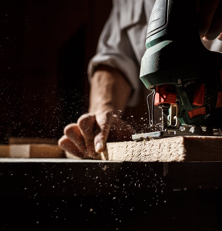man working on a piece of wood with a jigsaw